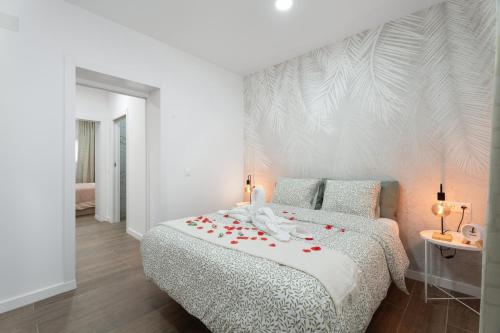 a white bedroom with a bed with roses on it at Casa Llano del Rey in Arona