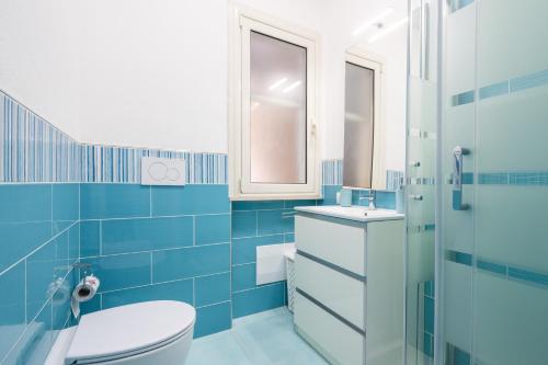 a blue bathroom with a toilet and a sink at Da doddo e beby in Santa Margherita di Pula