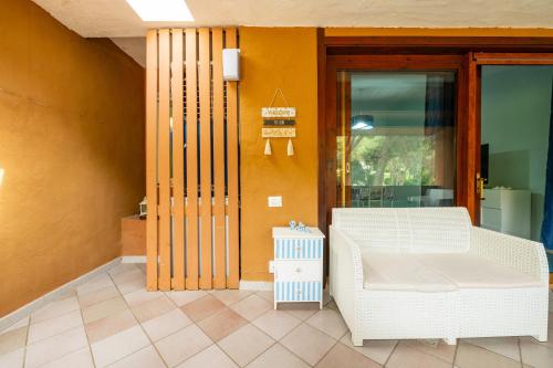 a porch with a white couch and a table at Da doddo e beby in Santa Margherita di Pula