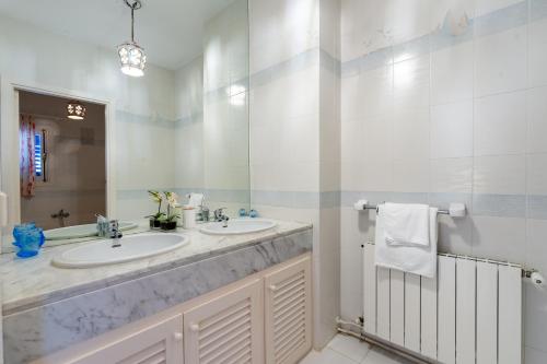 a bathroom with two sinks and a large mirror at Villa Renate in Sant Josep de sa Talaia