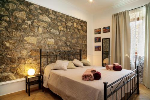 a bedroom with a bed and a stone wall at Casa Carly Taormina in Taormina