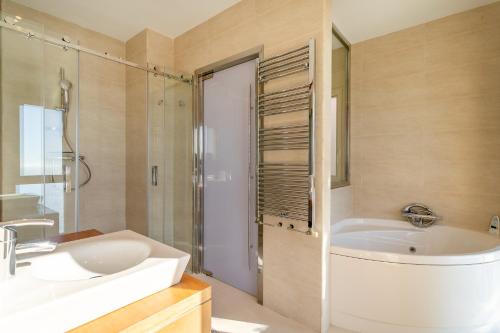 a bathroom with a tub and a sink and a shower at Villa Mina - First Line Villa in El Campello