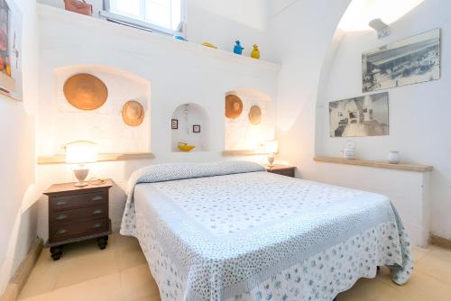 a white bedroom with a bed and two lamps at Villa Riggia - La Masseria in Nardò