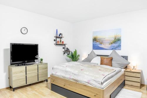 a bedroom with a bed and a flat screen tv at Angie's Ferienapartment Thermalbad in Bad Staffelstein