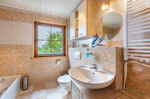 a bathroom with a sink and a tub and a toilet at Fewo unterm Dreifaltigkeitsberg in Balgheim