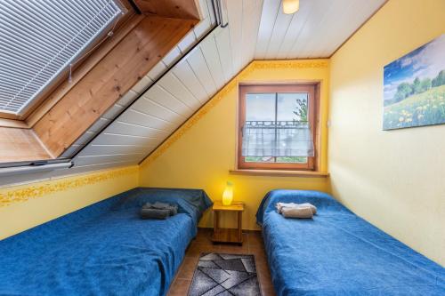 two beds in a room with a window at Fewo unterm Dreifaltigkeitsberg in Balgheim