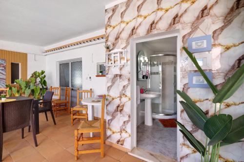 a dining room with a marble wall at J R Dream house in Quarteira