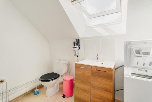 a bathroom with a toilet and a sink at Le Saint Martin Duplexe à la Mer in Bréhal