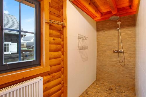 a bathroom with a shower and a window at Holzhaus Mühlenblick mit Whirlpool in Medebach