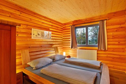 a bedroom with two beds in a log cabin at Holzhaus Mühlenblick mit Whirlpool in Medebach
