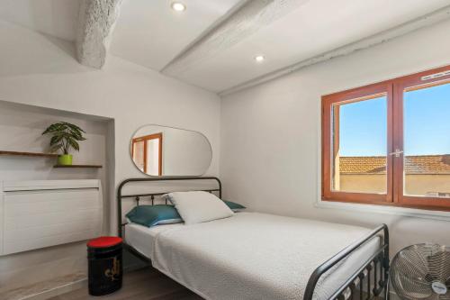 a bedroom with a bed and a window at Maison de ville Fréjus in Fréjus