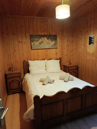 a bedroom with a large bed with wooden walls at Chalet Rivage Home in Pont-de-Poitte