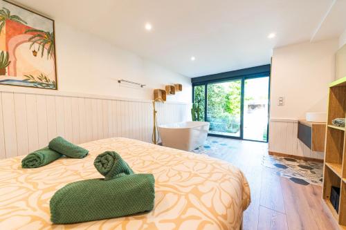 a bedroom with a bed with green towels on it at Eden Balinais in Le Muy