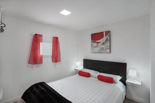 a bedroom with a bed with two red pillows at Villa Monica B in Agüimes