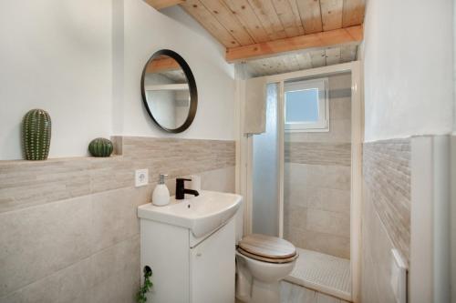 a bathroom with a toilet and a sink and a mirror at Villa Monica B in Agüimes