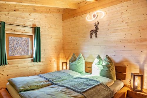 a bedroom with a bed in a wooden wall at Haus Glückswiese in Großhartberg