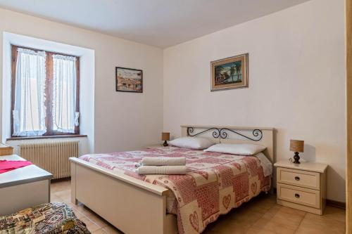 a bedroom with a bed and a window at Appartamento Al Sasso Rosso Dimaro in Dimaro
