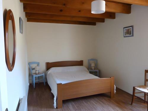 a bedroom with a bed and a wooden ceiling at Maison Quercynoise in Corn