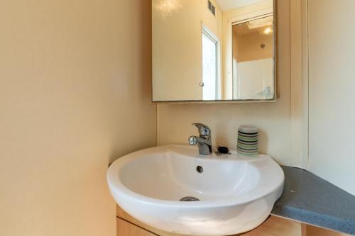 a bathroom with a white sink and a mirror at Mobilhome kervoyal 56 in Damgan