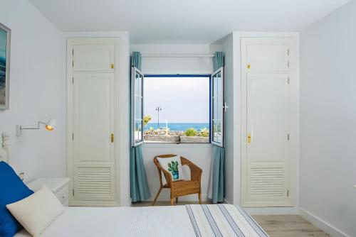 a bedroom with a bed and a chair and a window at Bungalow 9 - Caleta Campos in Arrieta