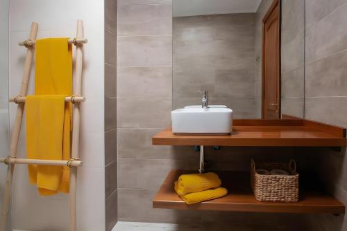 a bathroom with a sink and yellow towels at Bungalow 9 - Caleta Campos in Arrieta