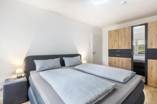 a bedroom with a large bed with blue sheets at Ferienwohnung Esselsteigblick in Eslohe
