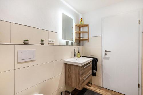 a white bathroom with a sink and a mirror at Ferienwohnung Esselsteigblick in Eslohe