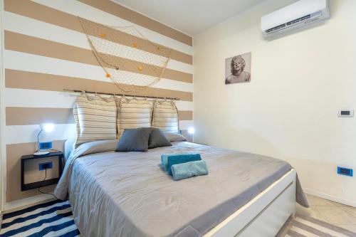 a bedroom with a large bed with two pillows on it at Casa Fiamma in Stintino