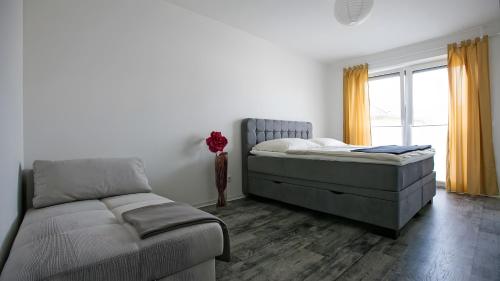 a bedroom with a bed and a couch and a window at Apartment by Janzen -E- in Rheine
