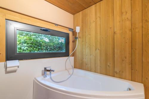 a bathroom with a tv on the wall and a sink at Tipi Lodge Glamp Marguerite in Le Boulou