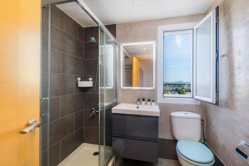 a bathroom with a toilet and a sink and a shower at Sweet Sea in Port d'Alcudia
