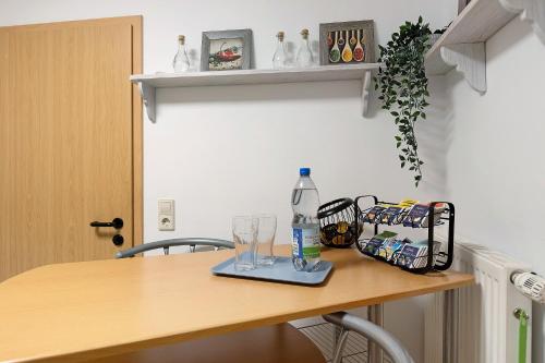 a table with a bottle of water and glasses on it at Ferienwohnung Ketterer in Hüfingen