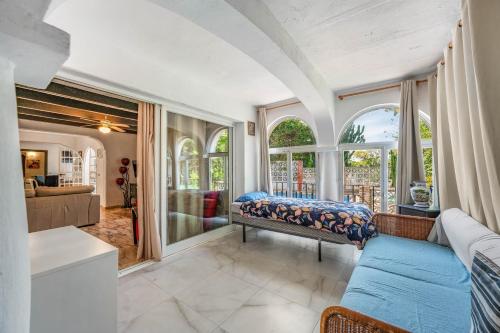 a bedroom with a bed in a room with windows at Villa Marbella -pool - Beach At 300 in Marbella