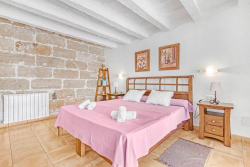 a bedroom with a large bed and a brick wall at Finca Son Sanxo in Alaior