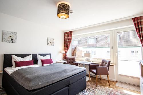 ein Schlafzimmer mit einem Bett, einem Schreibtisch und einem Tisch in der Unterkunft Syltbrise 22 in Sylt
