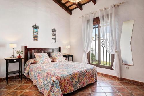 a bedroom with a bed and a large window at Villa Elsa in Conil de la Frontera