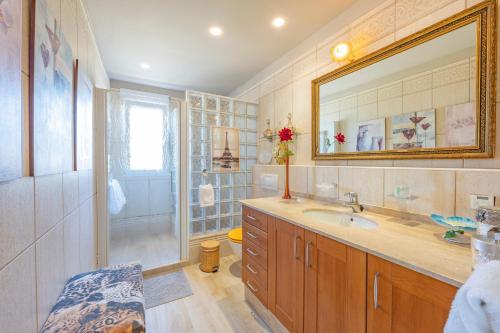 a bathroom with a sink and a mirror and a shower at Sconto in L'Alfàs del Pi