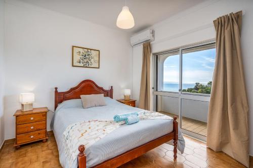 a bedroom with a bed and a large window at Vivenda Estrela do Mar in Carvoeiro
