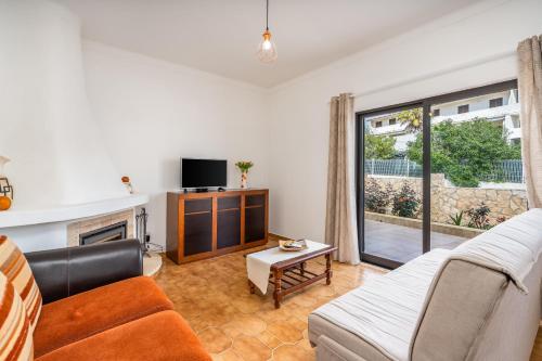 a living room with a couch and a tv at Vivenda Estrela do Mar in Carvoeiro