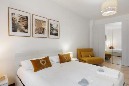 a bedroom with a white bed and a yellow chair at Dream Room Apartment in Illasi