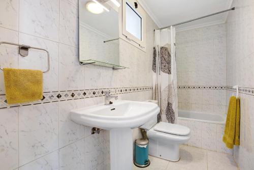 a white bathroom with a sink and a toilet at Casa sam in Caleta De Fuste