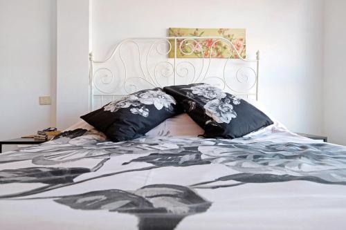 a bed with black and white sheets and pillows at Casa sam in Caleta De Fuste