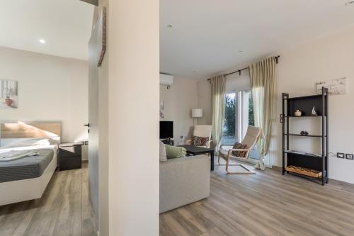 a bedroom and living room with a bed and a desk at Euphoria Apartments in Lixouri