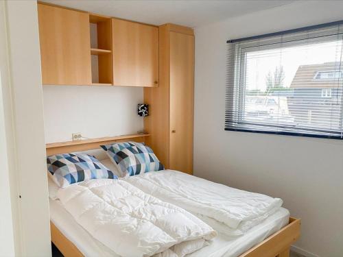 a small bedroom with a bed and a window at Blauwborst 24-18 in Breukelen