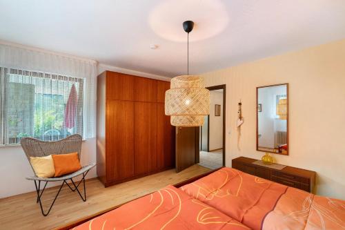 a bedroom with a bed and a chair and a window at Haus Schindler in Ottenhöfen
