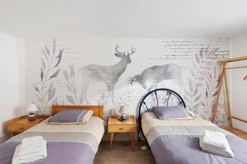 two beds in a room with a wall mural at Gîte Du Centre avec terrasse in Romorantin
