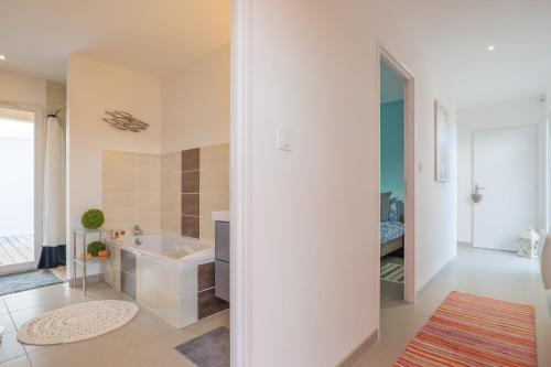 a white bathroom with a tub and a sink at Villa M Vallon Pont d'arc in Vallon-Pont-dʼArc