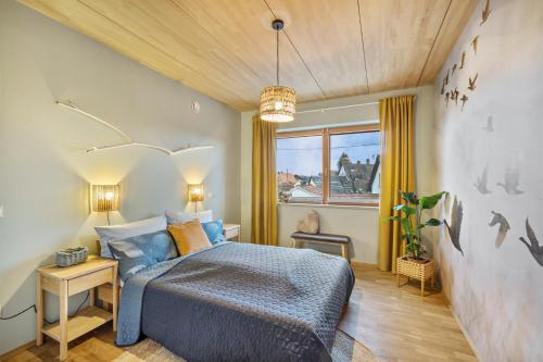 a bedroom with a blue bed and a window at Fewo Mit Herz Und Holz Penzing in Penzing
