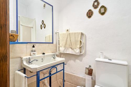 a bathroom with a sink and a toilet and a mirror at Villa Carlitos in Comares