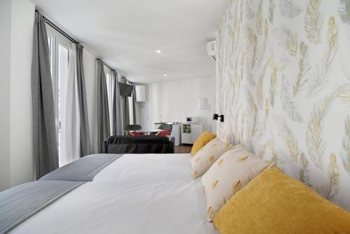 a bedroom with a large white bed with yellow pillows at Casa Milano 1 in Jerez de la Frontera